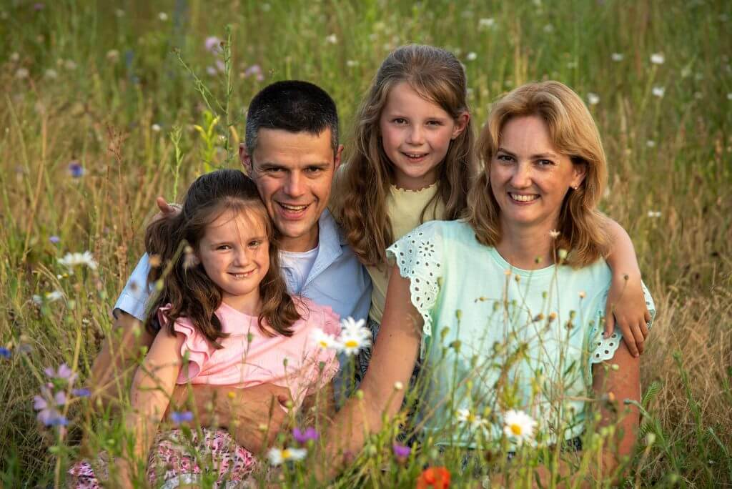 Familie genietend in een bloemenveld tijdens fasmiliefotografie