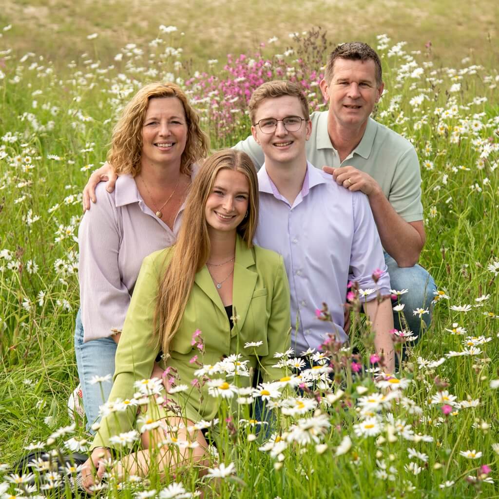 Ouders met kinderen in een bloemenveld tijdens familiefotografie